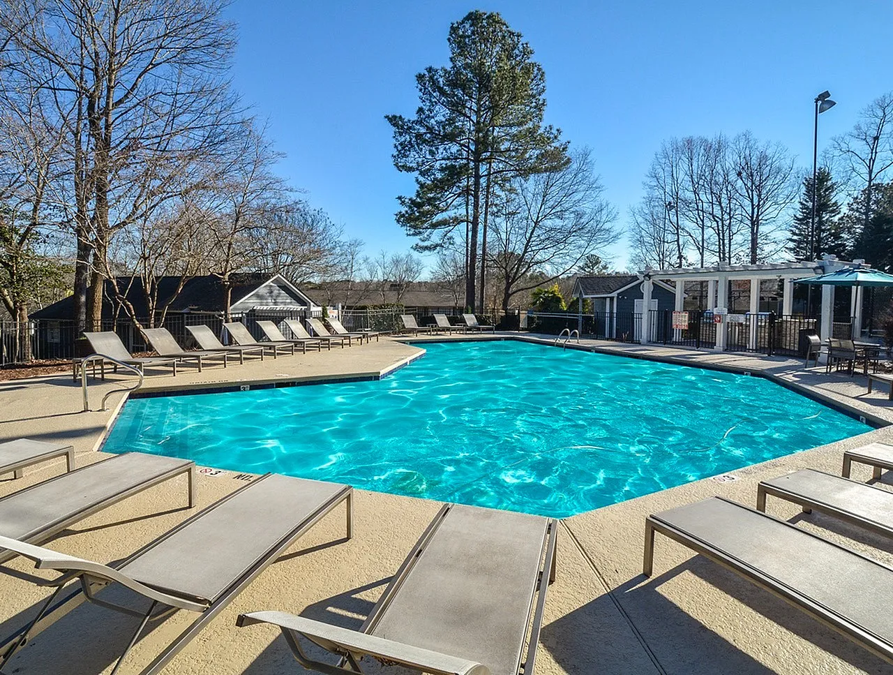 Pool area, turquoise water, lounge chairs, pergola structure, mature trees