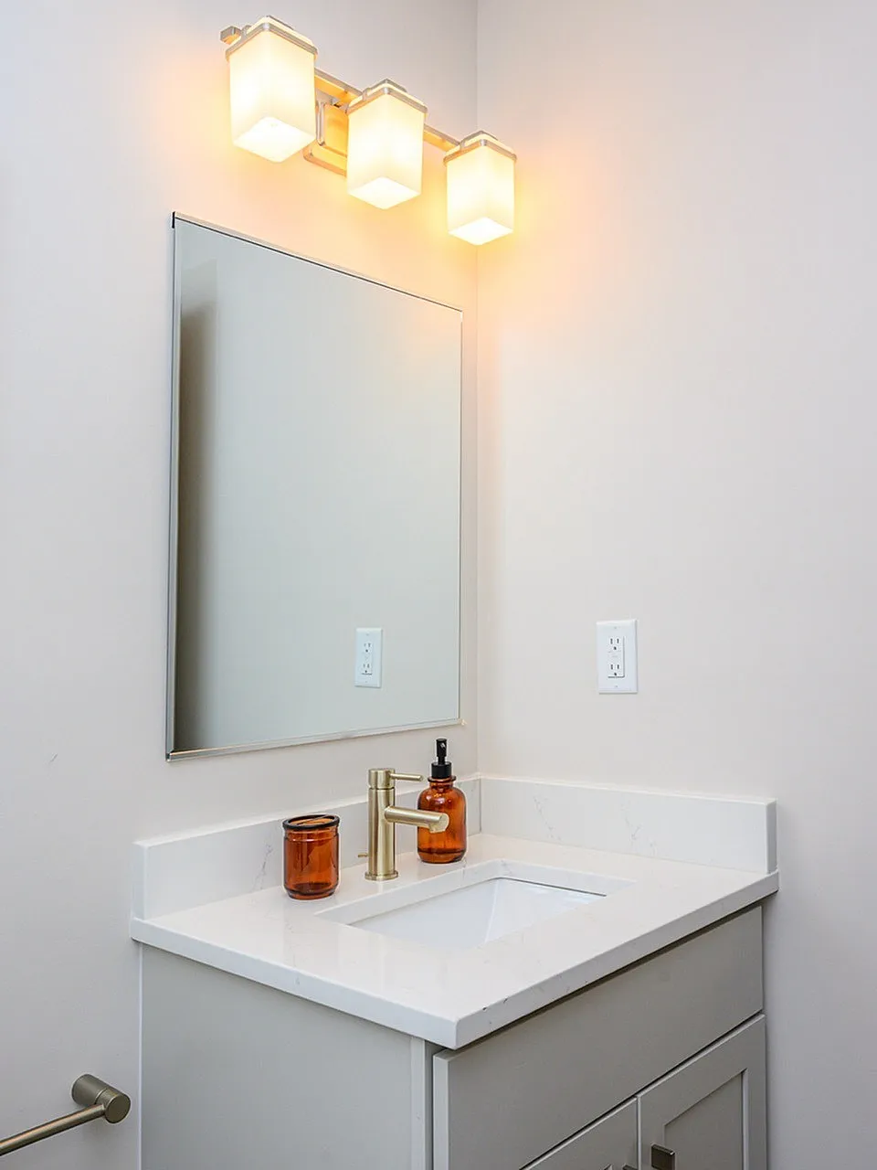 Bathroom vanity, white quartz countertop, white cabinetry, mirror, hexagonal light fixture
