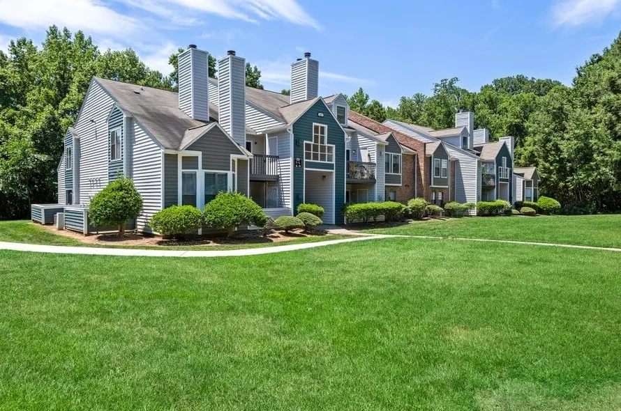 Community exterior, landscaped lawn, walking path, mature trees