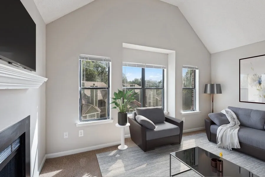 Living room, vaulted ceiling, large windows, wall-to-wall carpet