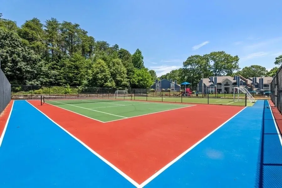 Tennis court, fenced enclosure, mature tree line