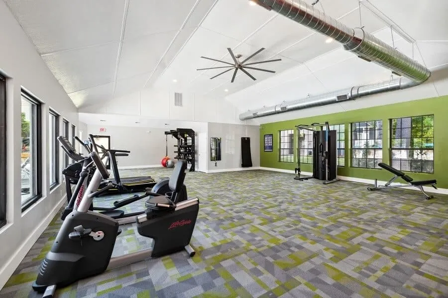 Fitness center, cardio equipment, vaulted ceiling, large windows