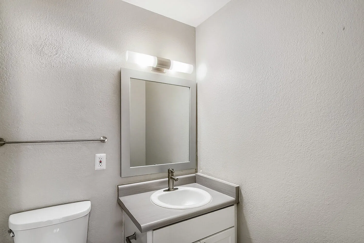 Vanity with framed mirror and light fixture