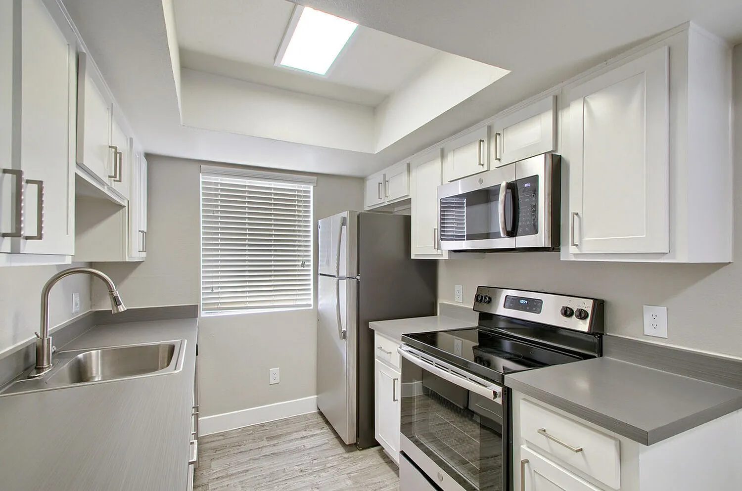 Electric range and built-in microwave with white shaker cabinets