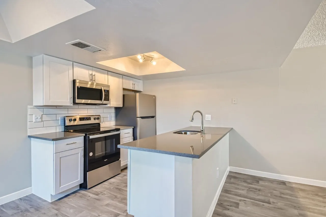 A1 Platinum kitchen with island, stainless steel appliances, and white cabinets