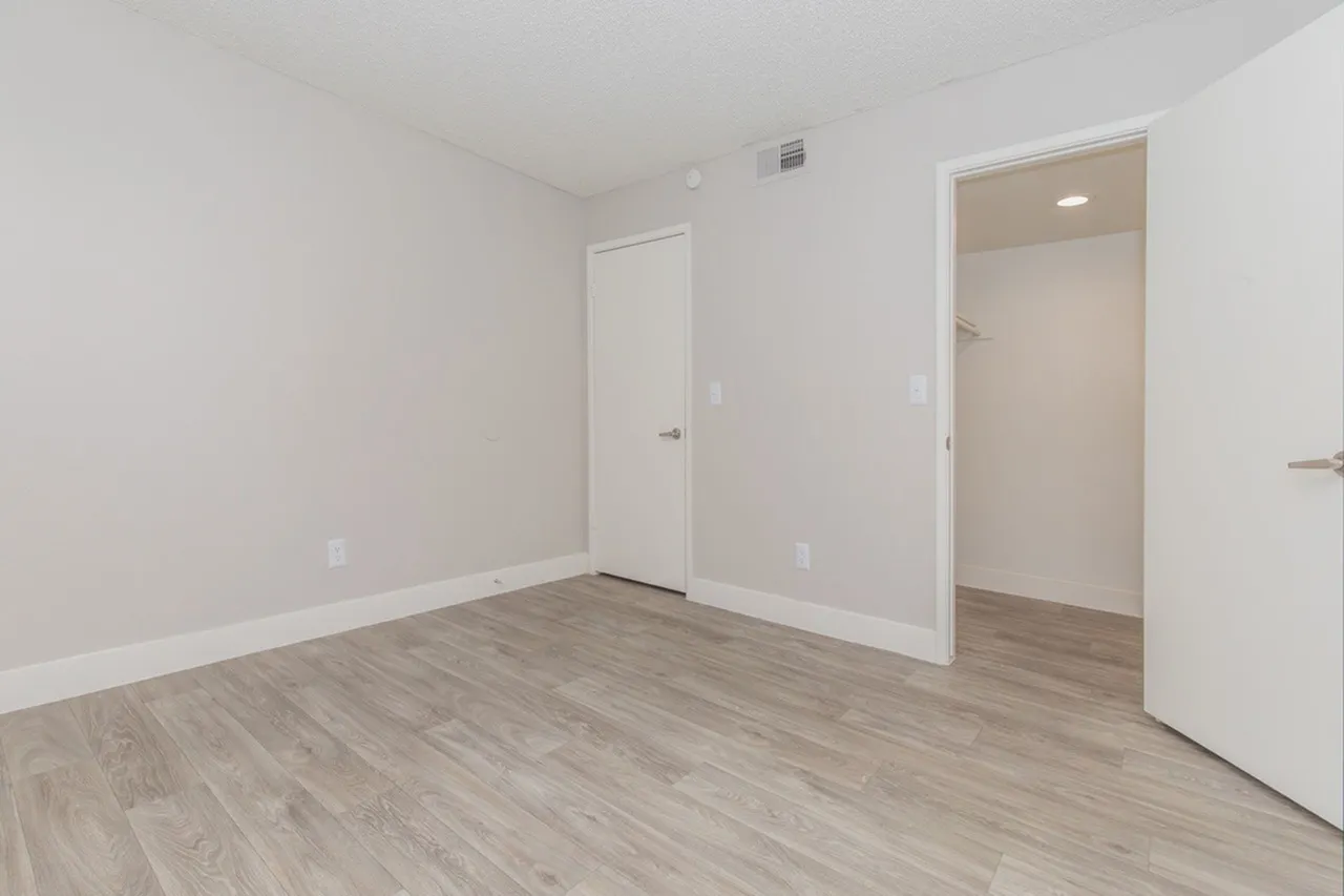 Bedroom with closet access and entry door