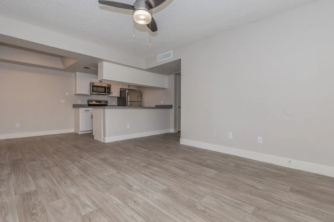 B1 Gold open living area and kitchen with wood-style plank flooring