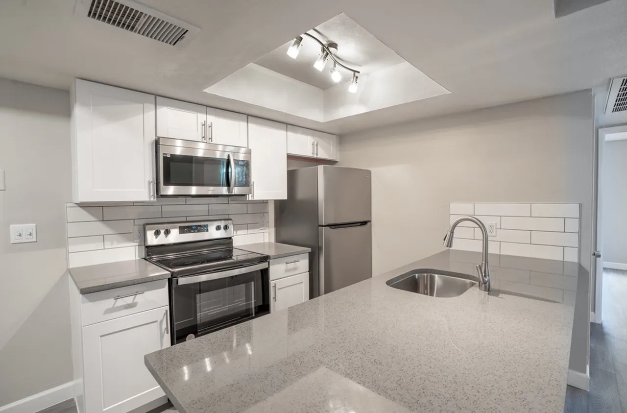 Kitchen with white cabinets, stainless steel appliances, and breakfast bar