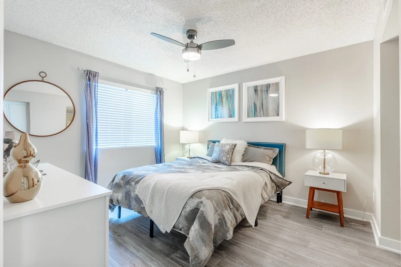 Primary bedroom with ceiling fan and large window