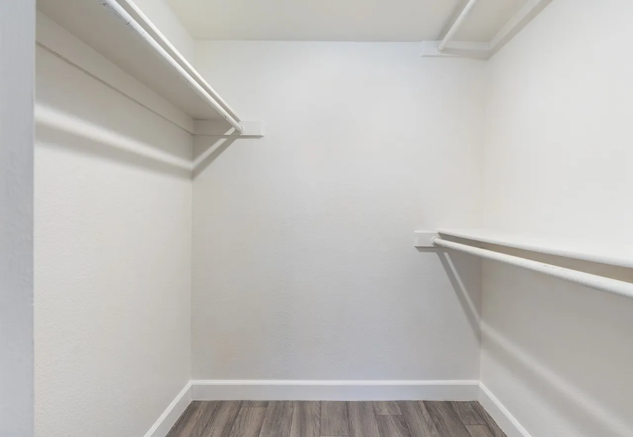 Walk-in closet with hanging rods and shelves