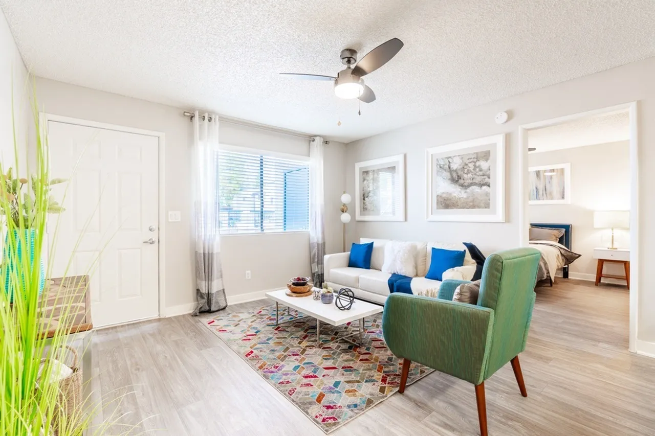 B2 Gold living room with ceiling fan, window, and wood-style plank flooring