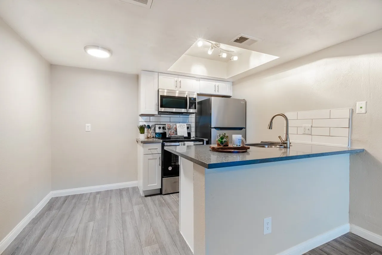 A3 Platinum kitchen with island, track lighting, and stainless steel appliances