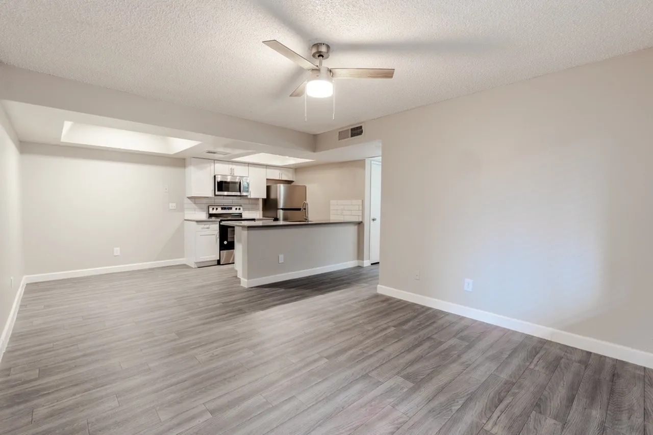 B1 Platinum living room open to kitchen island with wood-style plank flooring