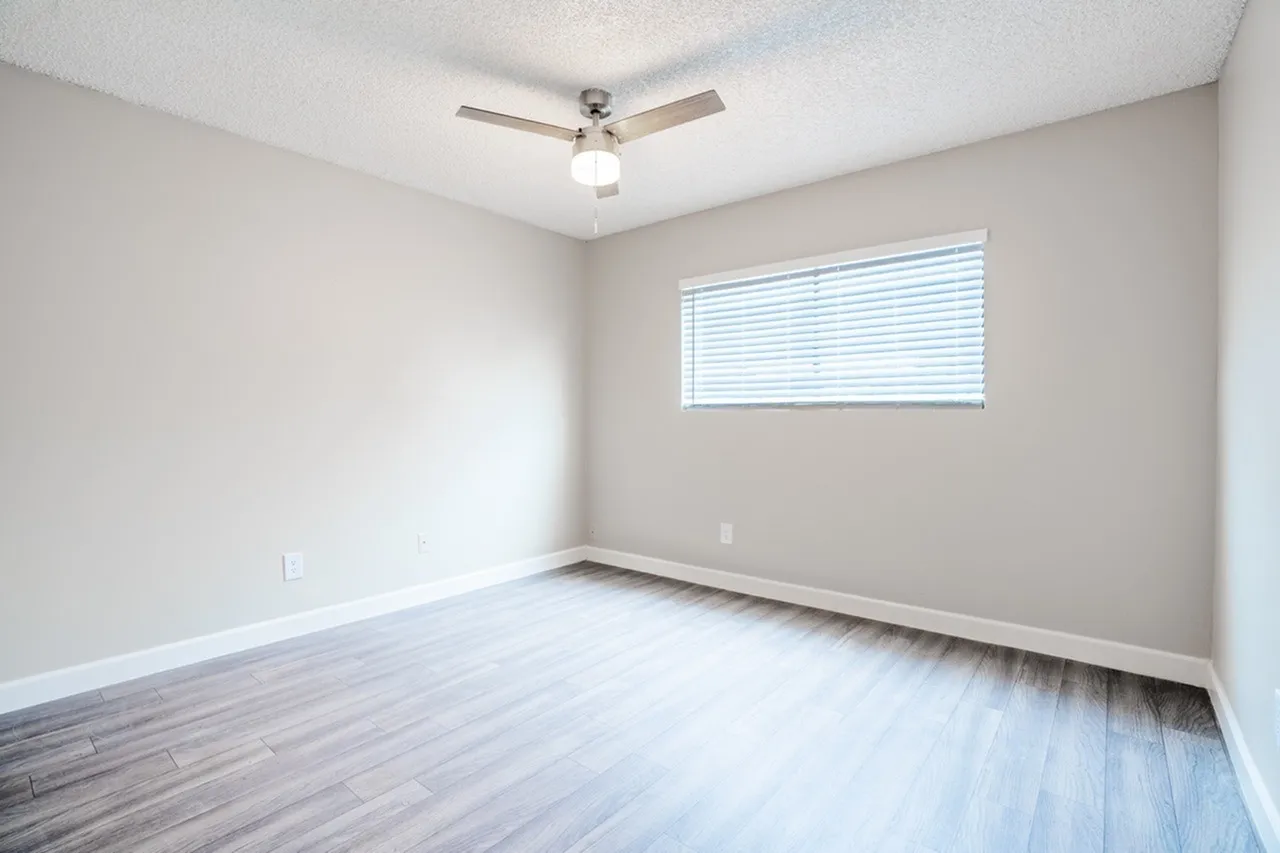 Bedroom with large window and ceiling fan