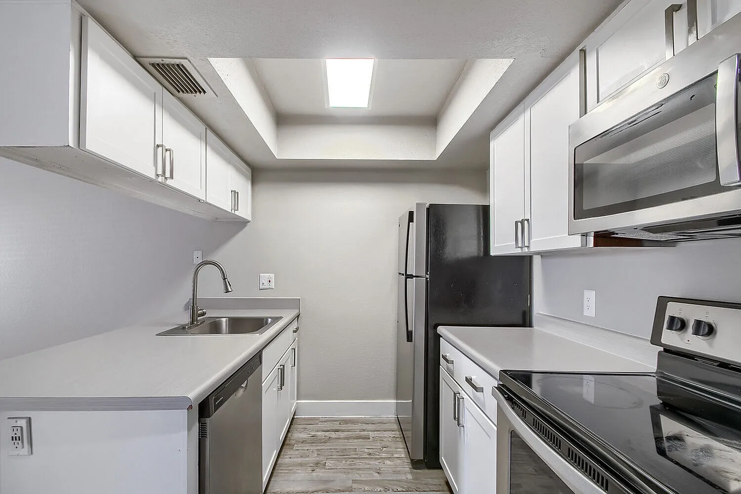 Kitchen with tray ceiling light and refrigerator