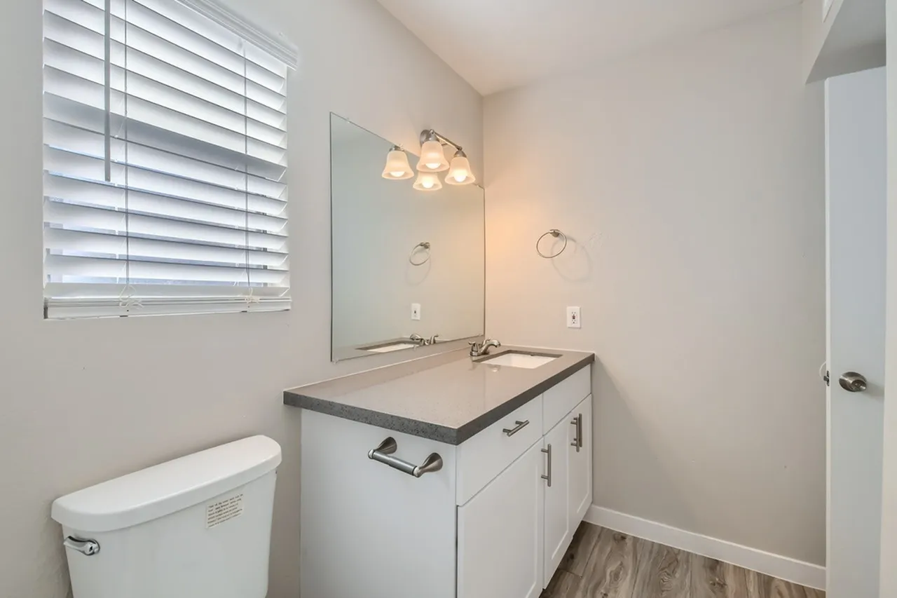 Vanity with gray countertop and large mirror