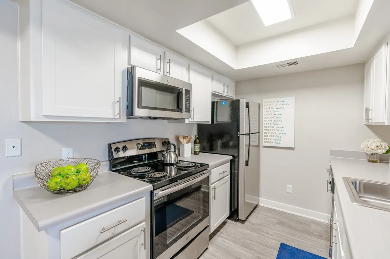 Electric range, microwave, and refrigerator with white shaker cabinets