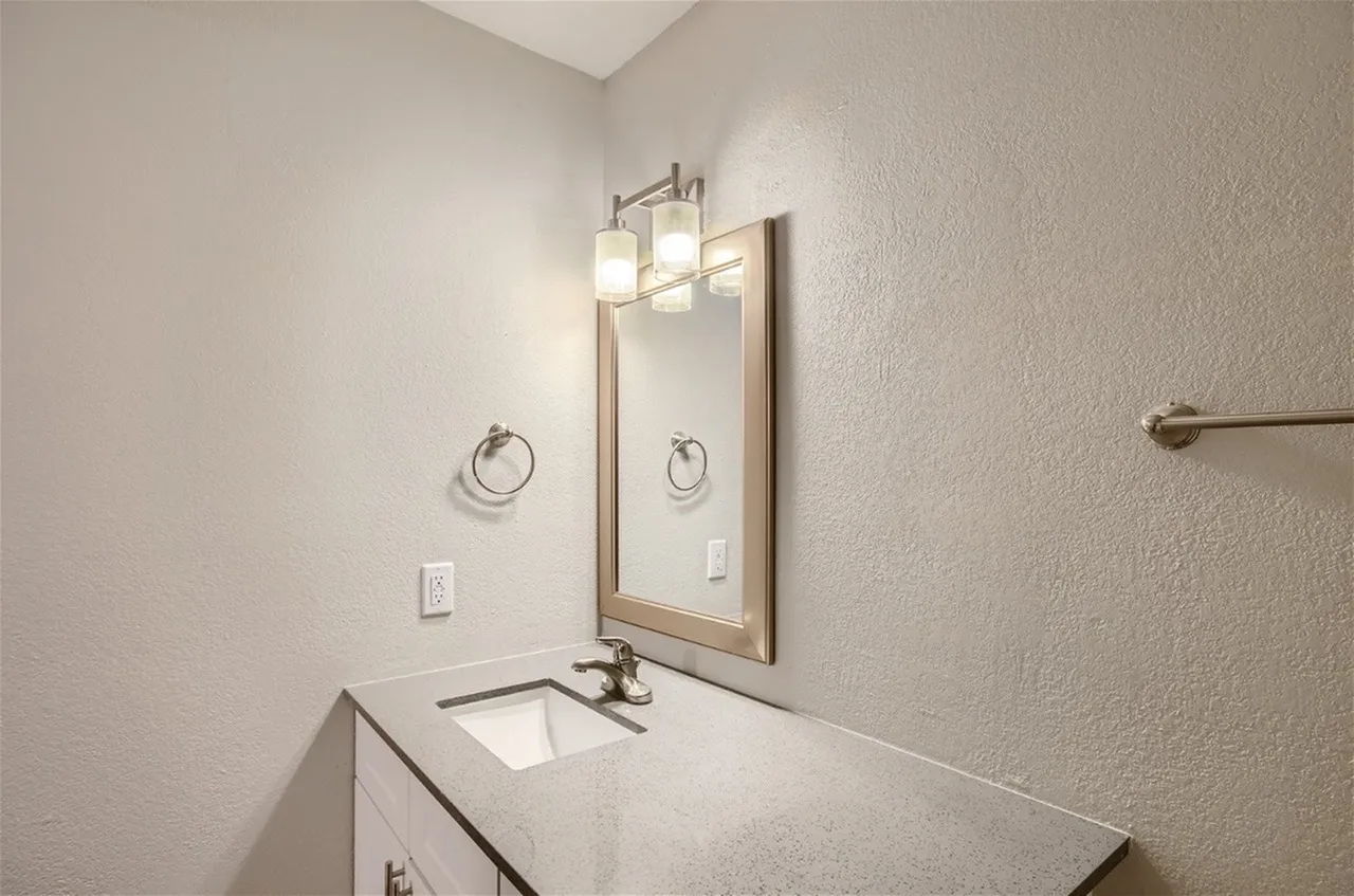 Vanity with modern light fixture and towel ring