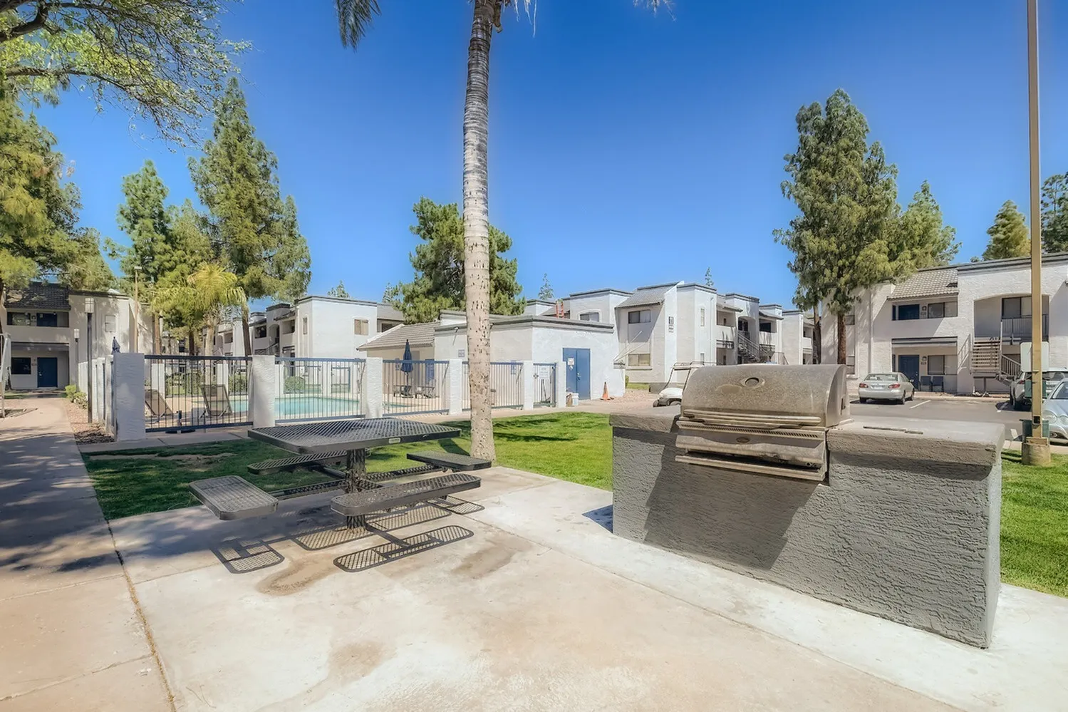 Outdoor grill station with picnic tables near pool