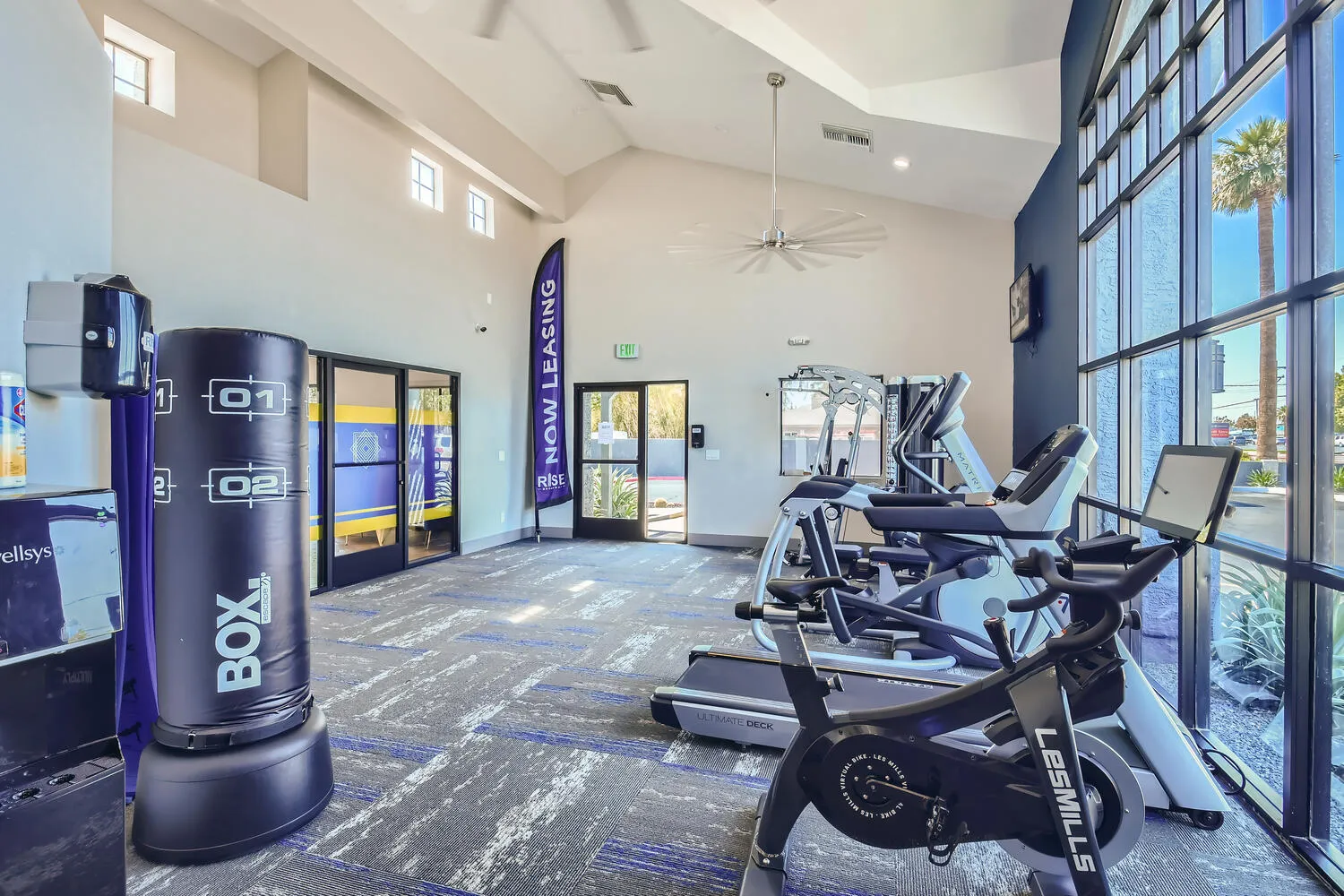 On-site gym with cardio machines and boxing bag at Mesa