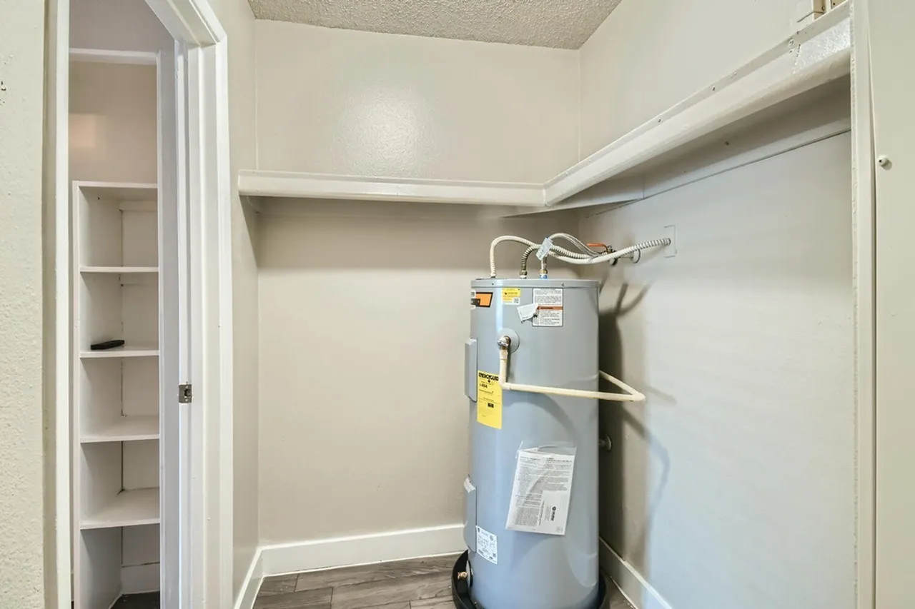 Utility room, water heater, shelving, wood-style plank flooring