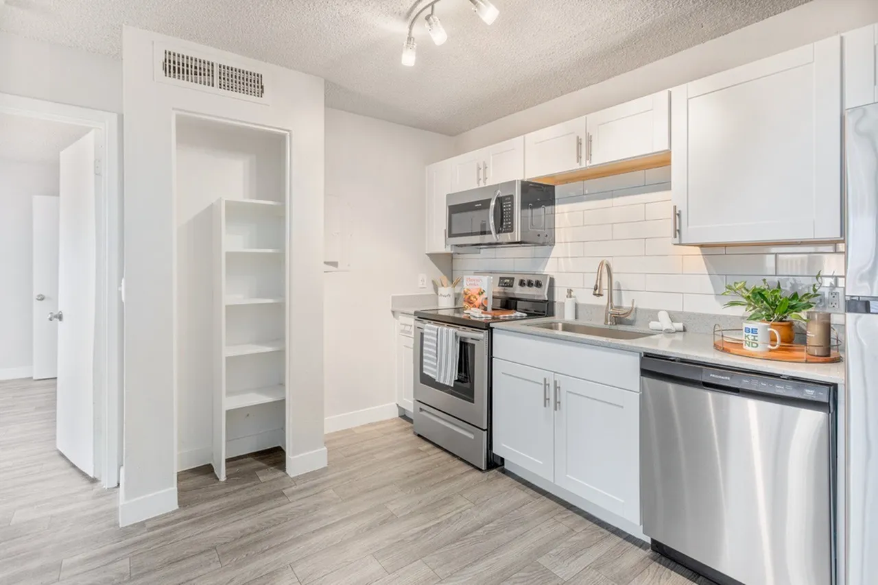 Kitchen, white shaker cabinetry, stainless appliances, subway tile backsplash, wood-style plank flooring