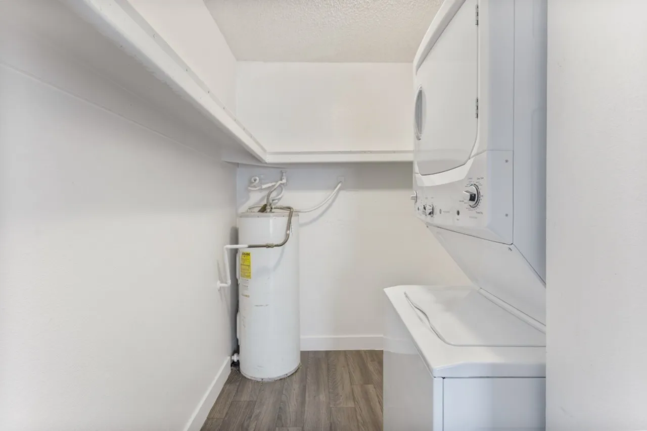 Laundry room, white washer and dryer, water heater, wood-style plank flooring
