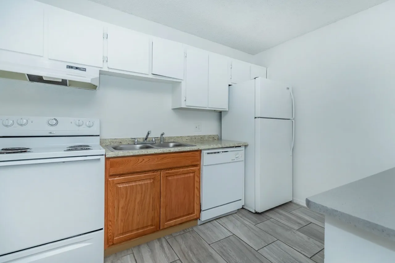 Kitchen, wood cabinetry, granite countertops, white appliances, wood-style plank flooring