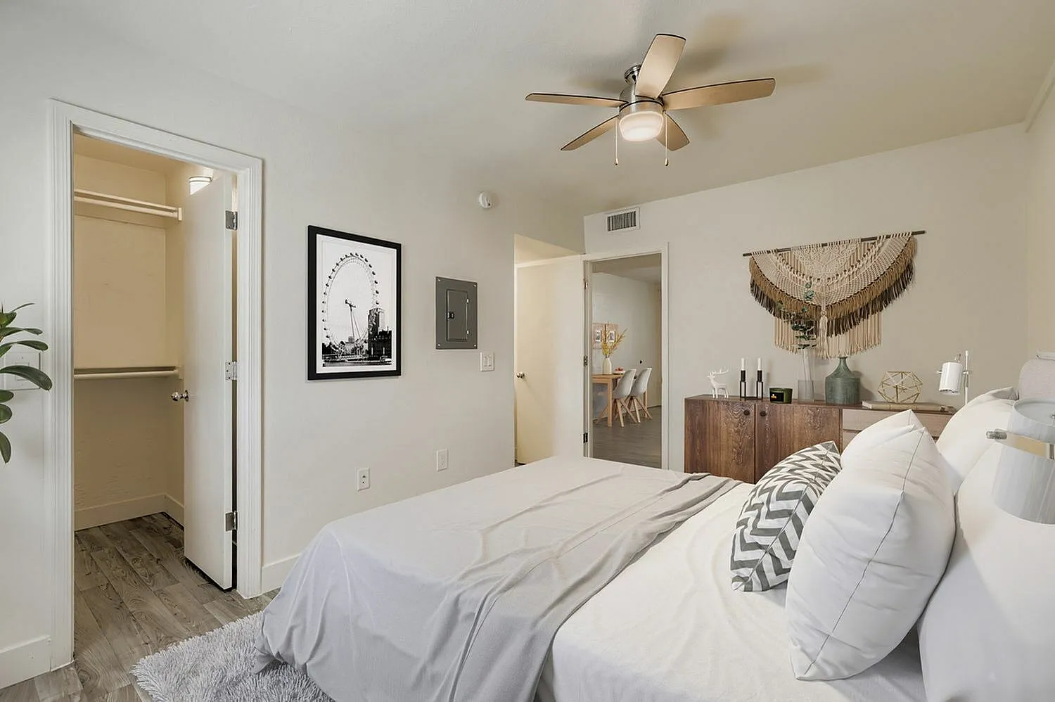 Primary bedroom, wood-style plank flooring, ceiling fan, walk-in closet