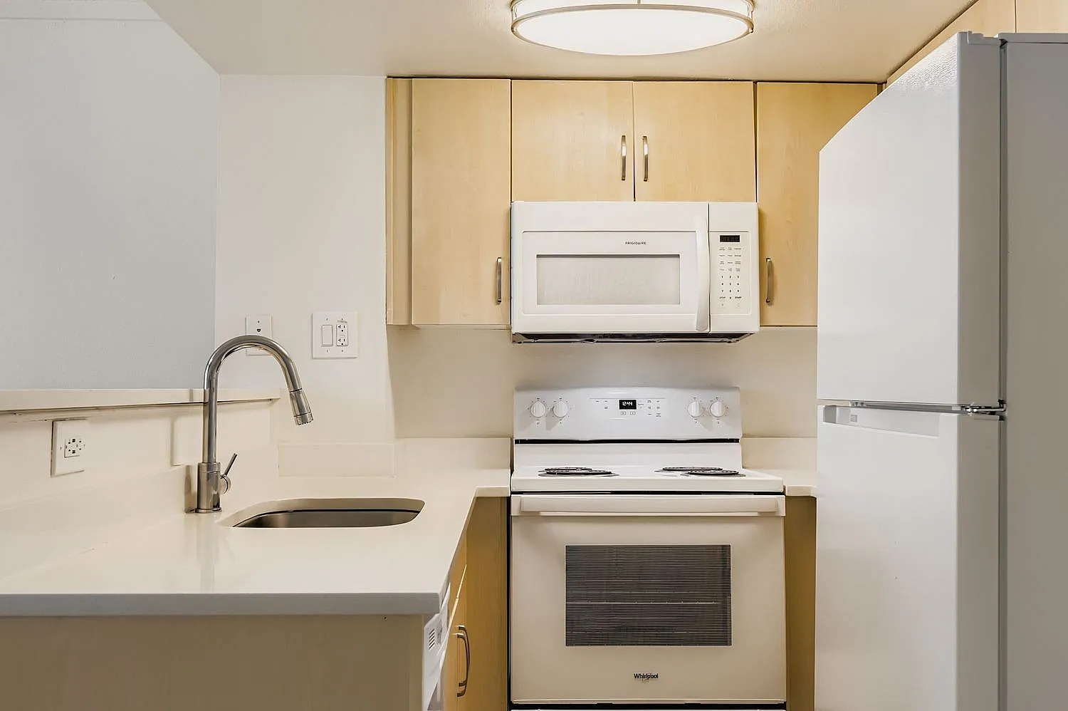 Kitchen, light wood cabinetry, white quartz countertops, stainless steel appliances