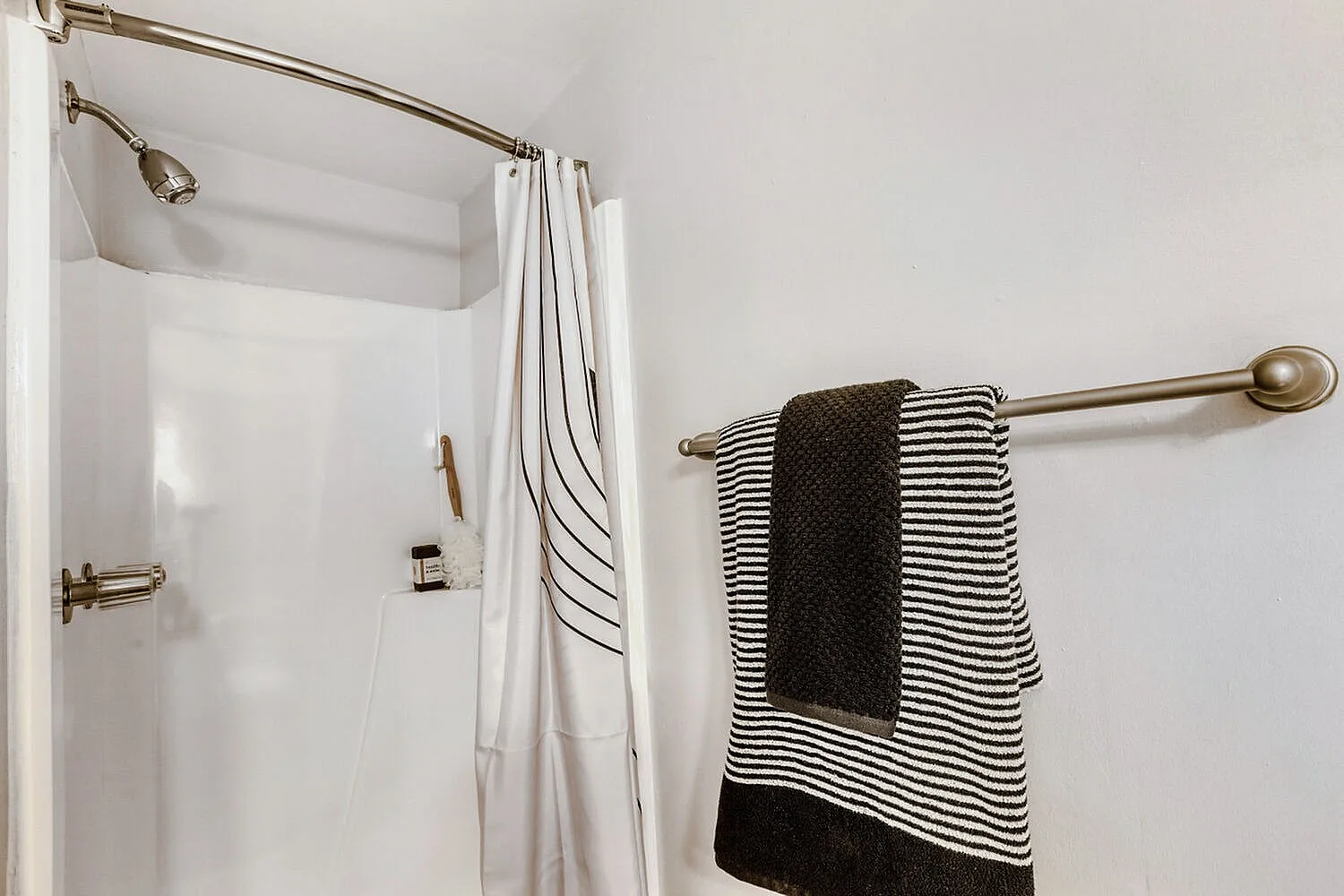 Bathroom, white subway tile shower, chrome fixtures, striped towel bar