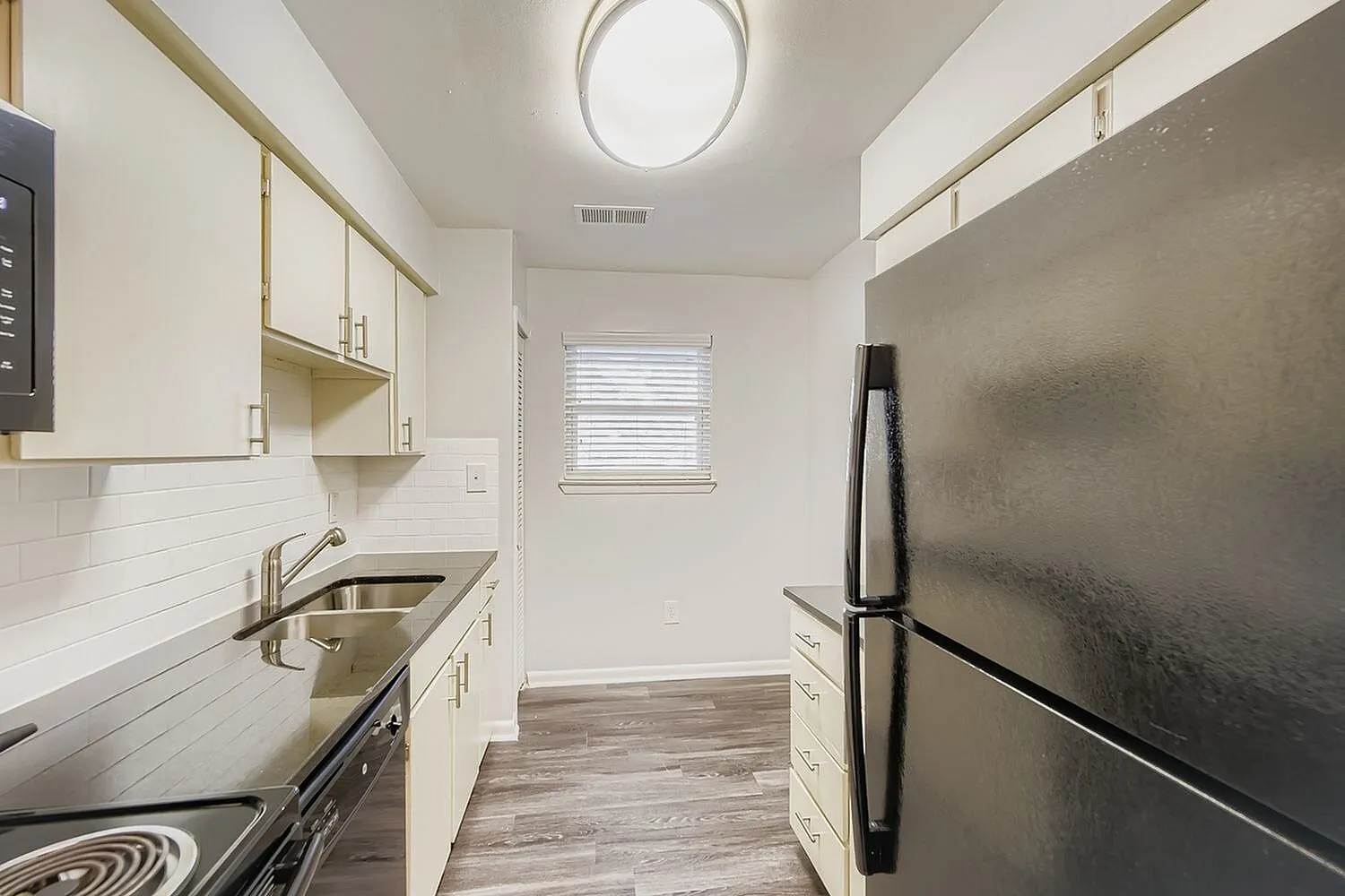 Kitchen, white shaker cabinetry, subway tile backsplash, stainless steel appliances, wood-style plank flooring