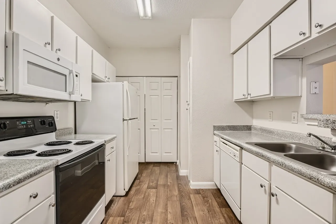 Kitchen, white shaker cabinetry, speckled quartz countertops, black electric range, stainless steel sink, wood-style plank flooring