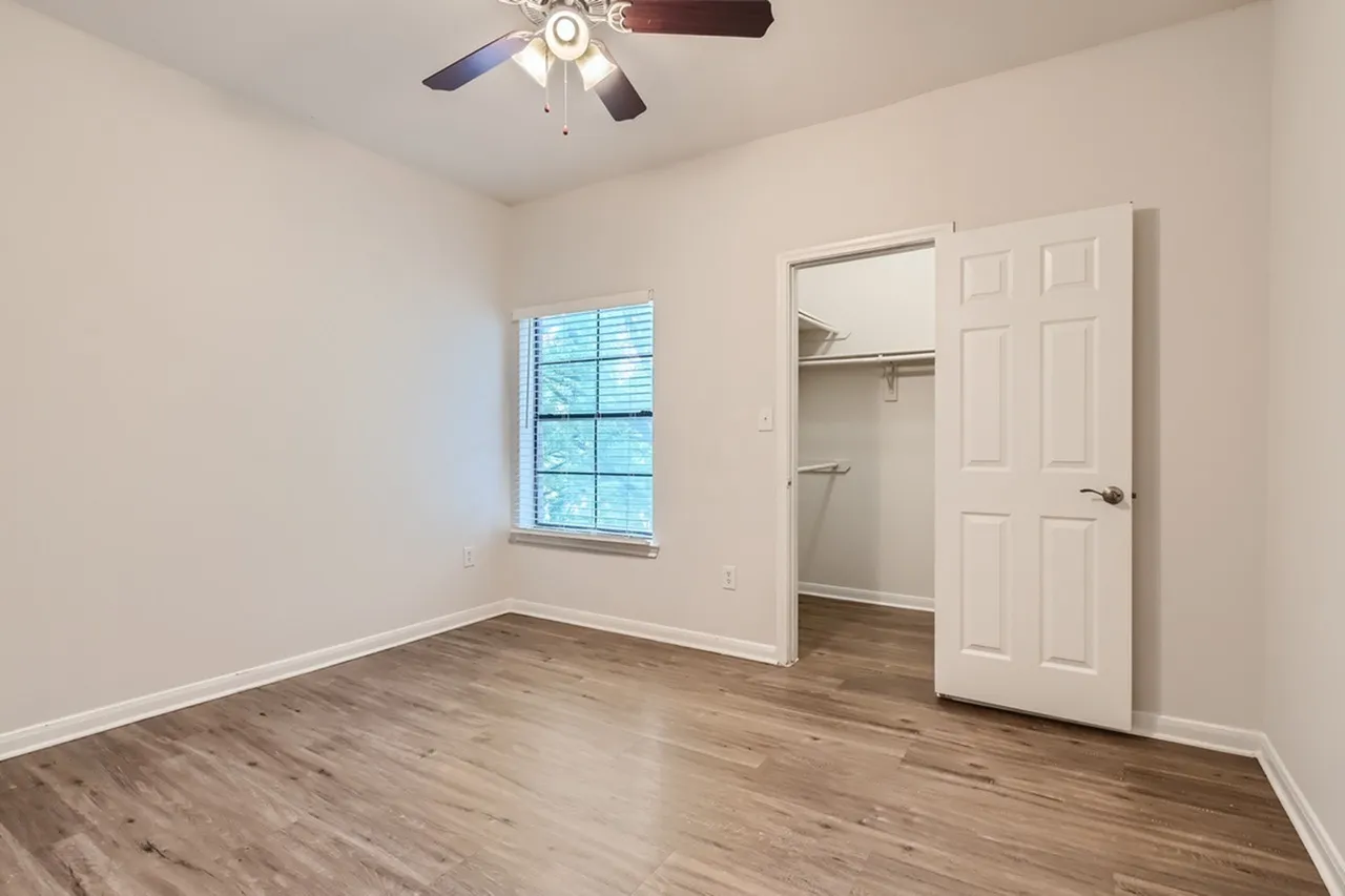 Bedroom, wood-style plank flooring, ceiling fan, window, open closet