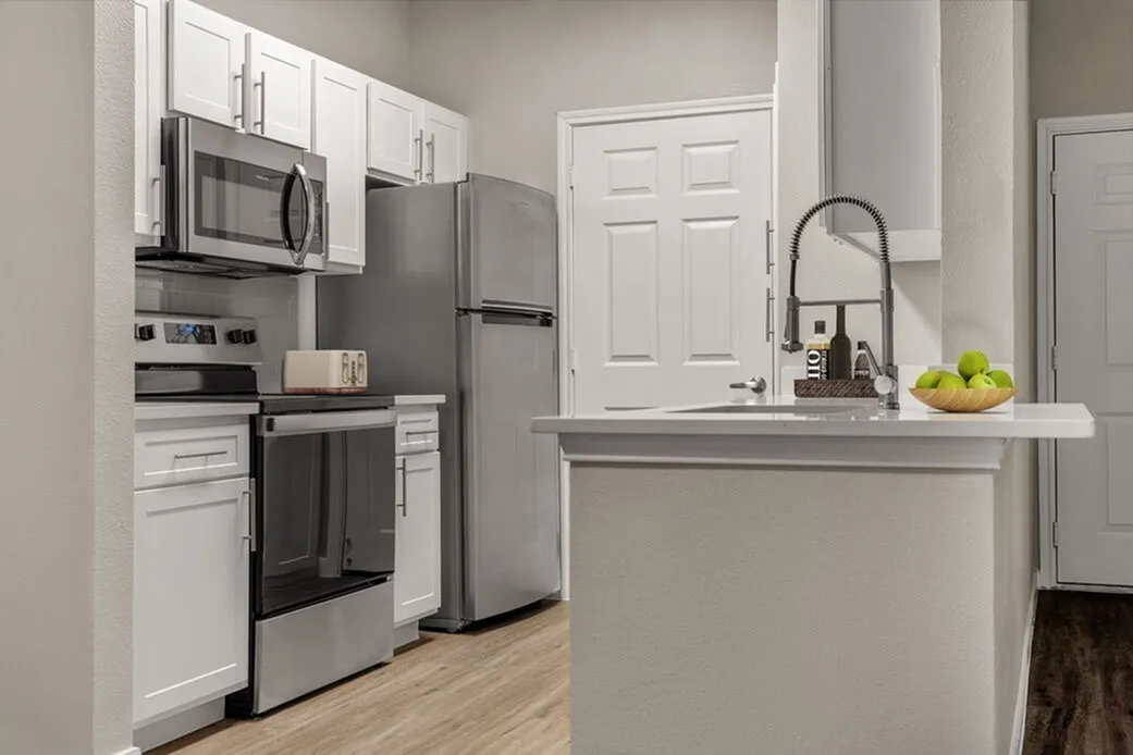 Kitchen, white shaker cabinetry, stainless steel appliances, quartz countertop, wood-style plank flooring