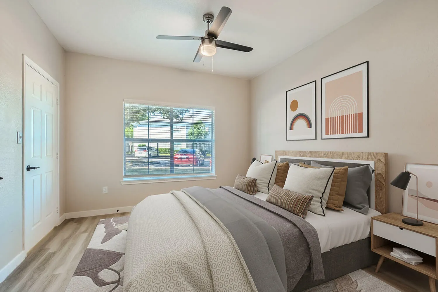 Primary bedroom, wood-style plank flooring, ceiling fan, large window