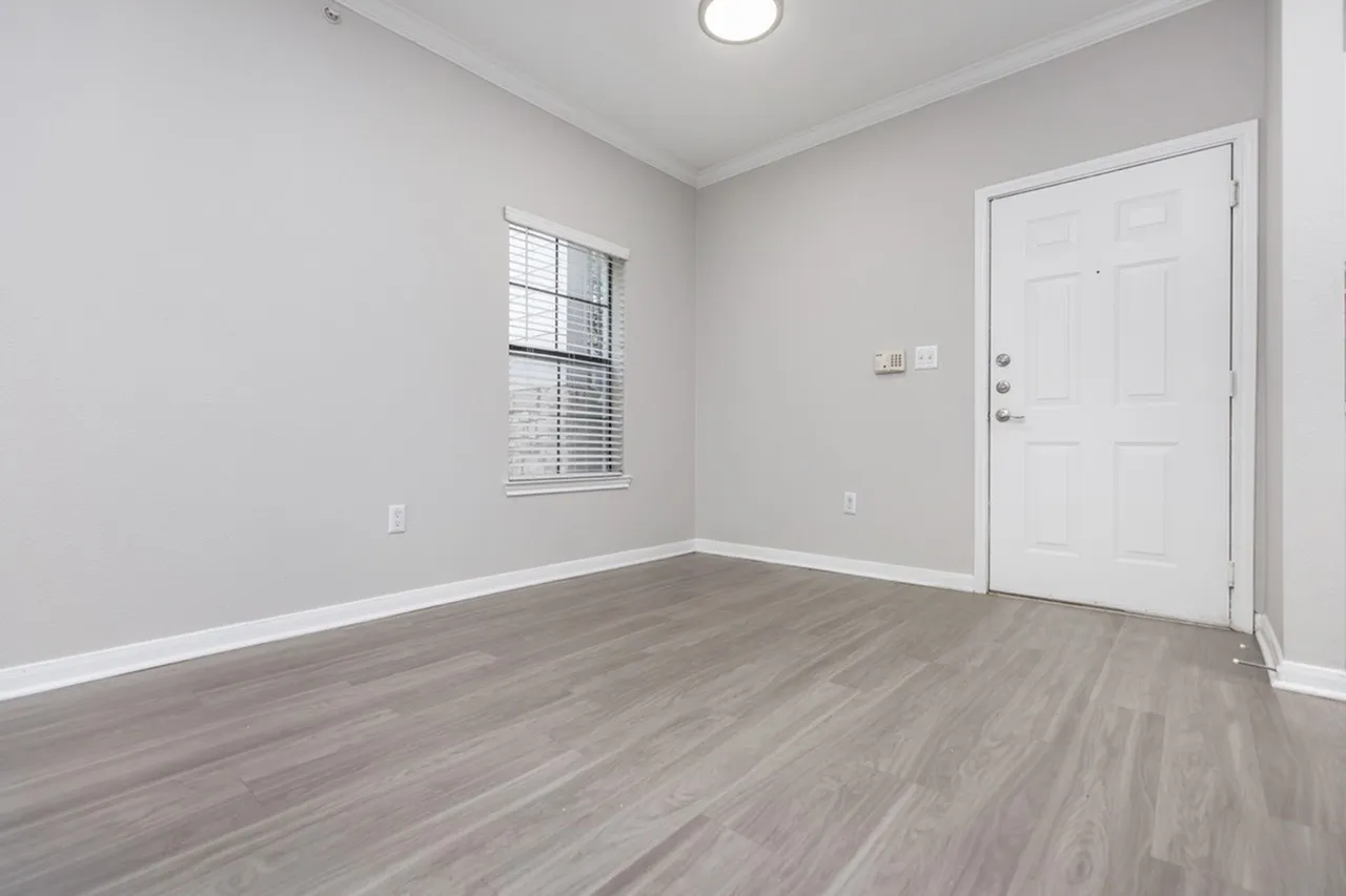 Bedroom, wood-style plank flooring, white door, window with blinds, ceiling light