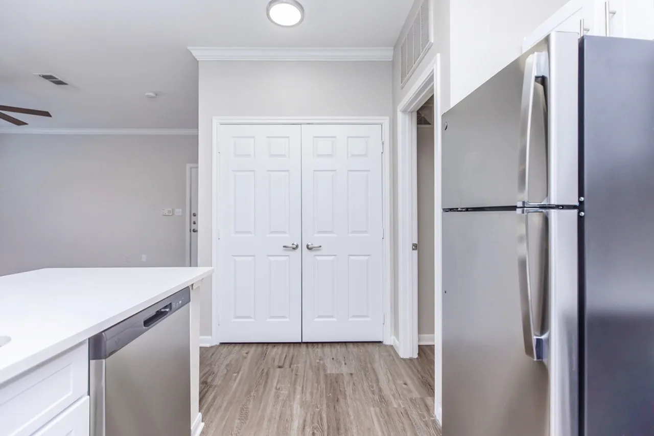 Kitchen, white shaker cabinetry, white quartz countertops, stainless steel refrigerator, wood-style plank flooring