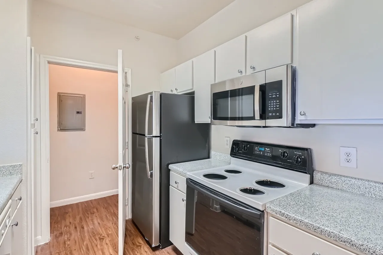 Kitchen, white shaker cabinetry, gray quartz countertops, stainless appliances, wood-style plank flooring