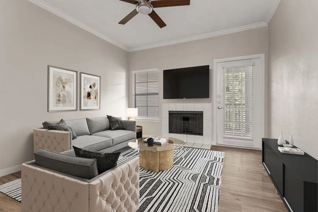 Living room, wood-style plank flooring, ceiling fan, wall-mounted TV above fireplace, glass door