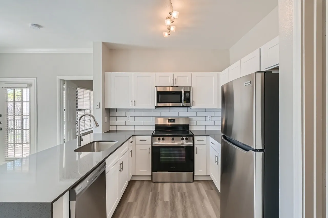 Kitchen, white shaker cabinetry, subway tile backsplash, stainless steel appliances, quartz countertops, wood-style plank flooring