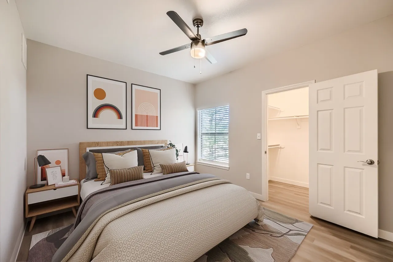 Primary bedroom, wood-style plank flooring, ceiling fan with light, modern artwork
