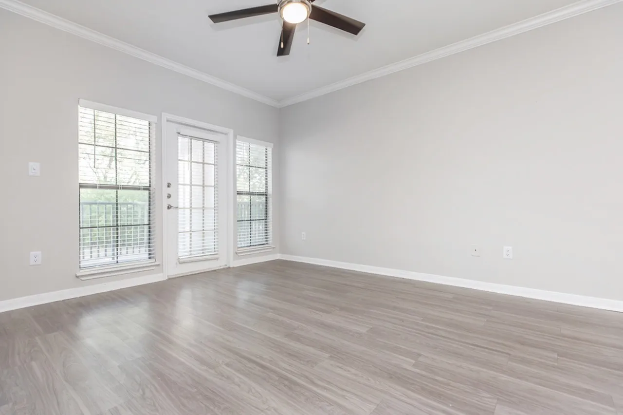 Bedroom, wood-style plank flooring, ceiling fan with light fixture, glass doors and windows
