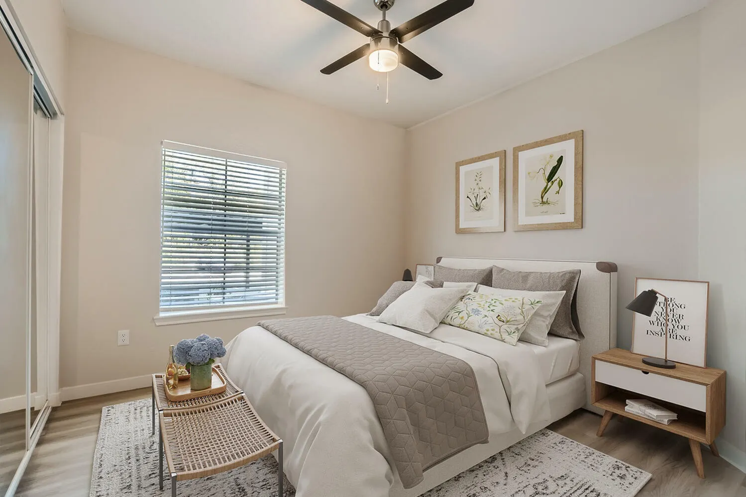 Primary bedroom, gray upholstered bed, wood-style plank flooring, ceiling fan, window with shutters