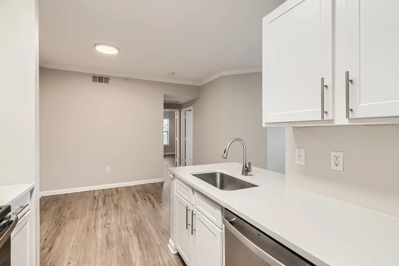 Kitchen, white shaker cabinetry, quartz countertops, stainless appliances, wood-style plank flooring