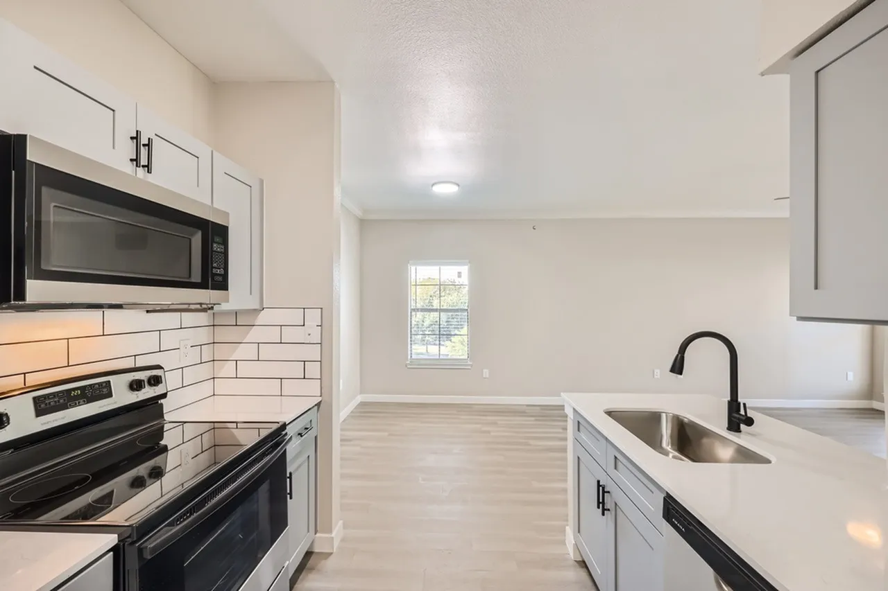 Kitchen, white shaker cabinetry, subway tile backsplash, stainless appliances, wood-style plank flooring