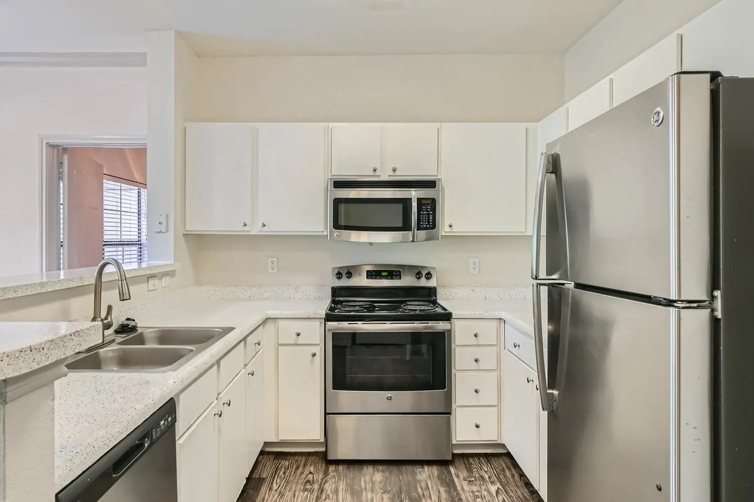 Kitchen, white shaker cabinetry, quartz countertops, stainless appliances, wood-style plank flooring