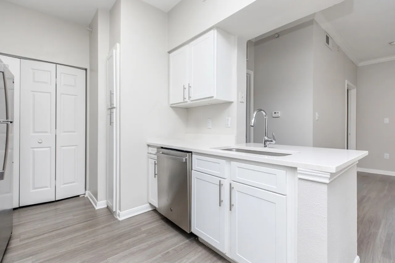 Kitchen, white shaker cabinetry, white quartz countertops, stainless appliances, wood-style plank flooring
