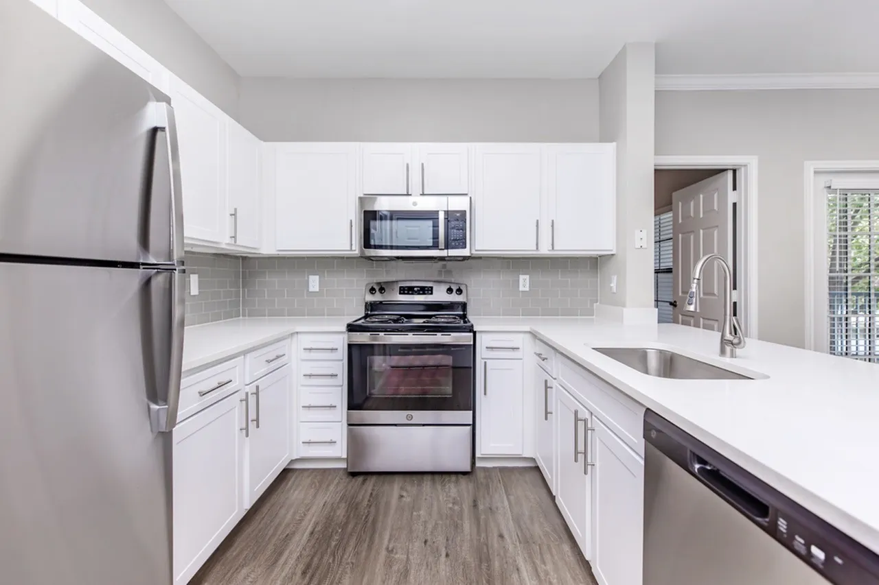 Kitchen, white shaker cabinetry, quartz countertops, stainless appliances, wood-style plank flooring