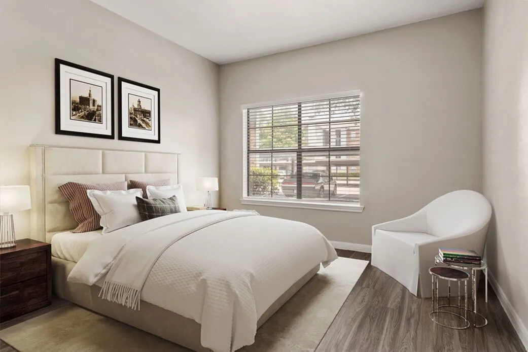 Primary bedroom, upholstered headboard, wood-style plank flooring, framed wall art, shuttered window
